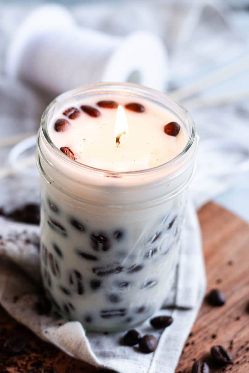 A beautiful coffee scented candle with coffee beans pressed against the sides. 