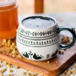 A homemade hand soak made from chamomile tea in a decorative mug.