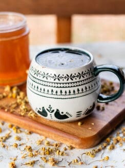 A homemade hand soak made from chamomile tea in a decorative mug.