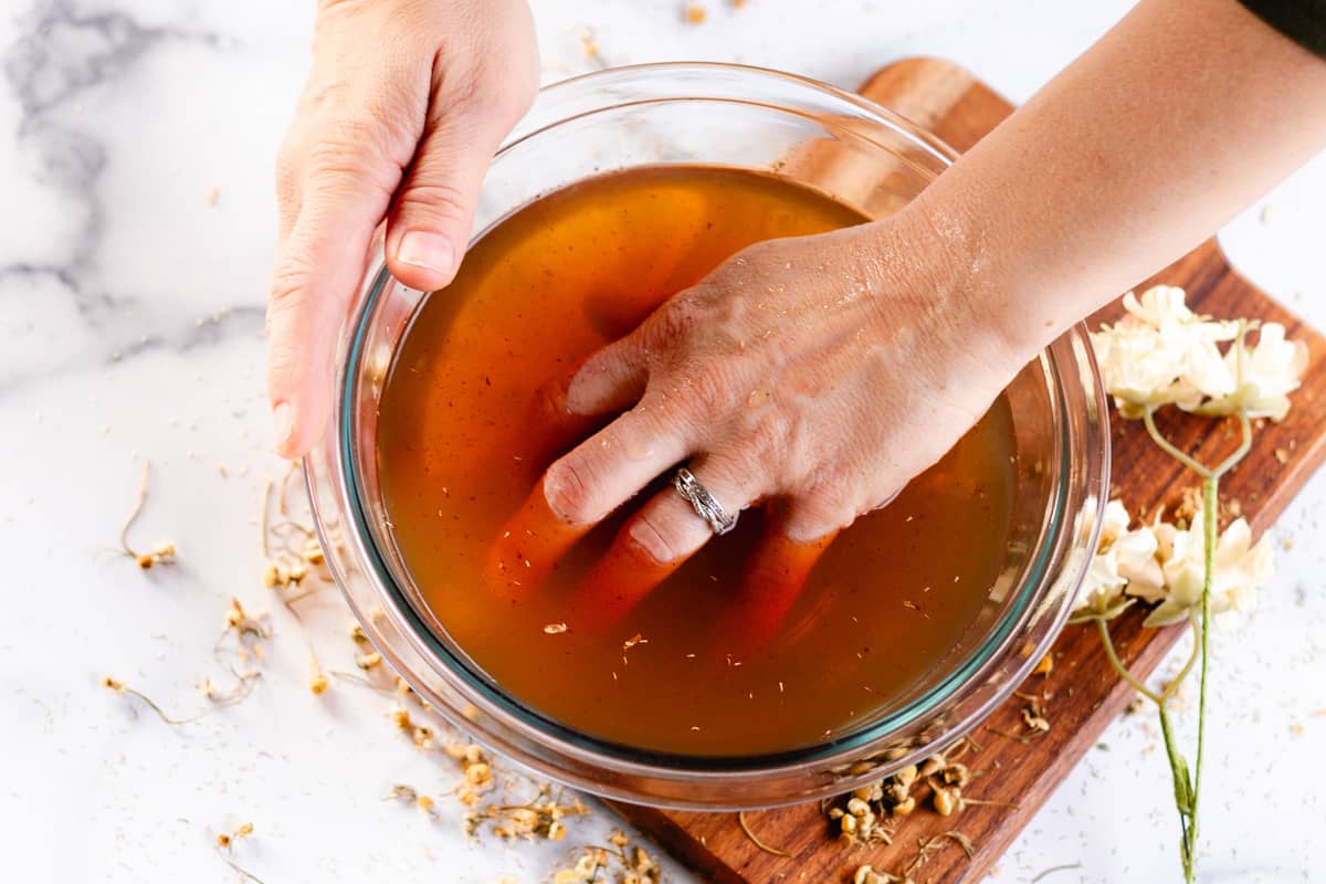 Soaking hands in a DIY hand soak recipe.