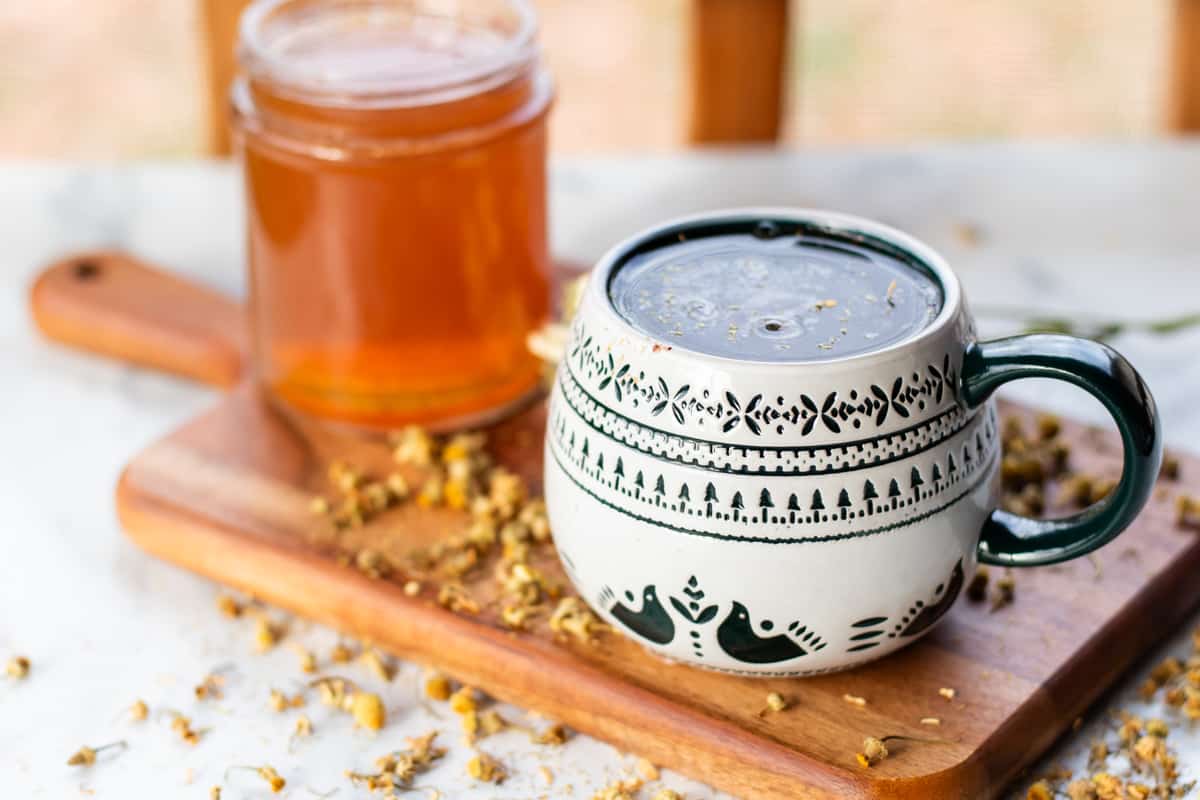 Chamomile tea hand soak cooling down in a mug.