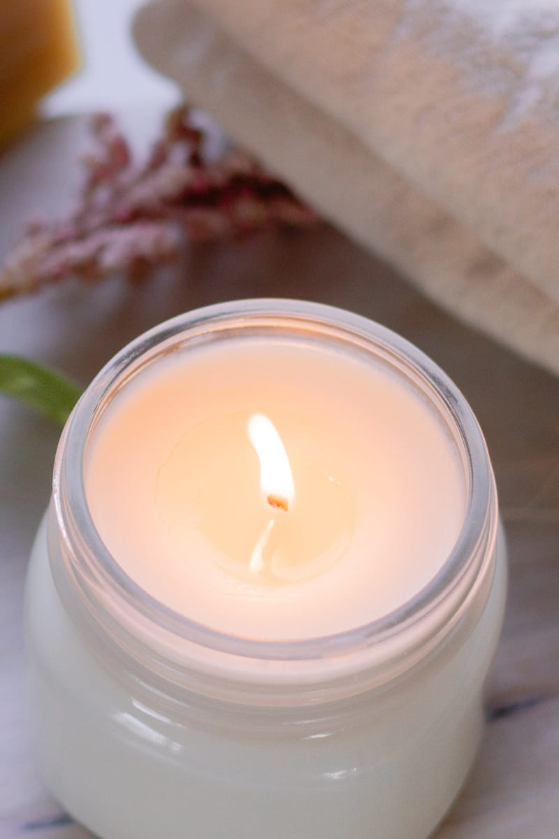 A beautiful homemade candle burning in the dimly lit room.