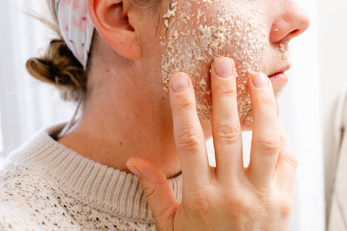 Applying my homemade oatmeal and coconut oil face mask onto the sides of my cheeks with my fingertips.