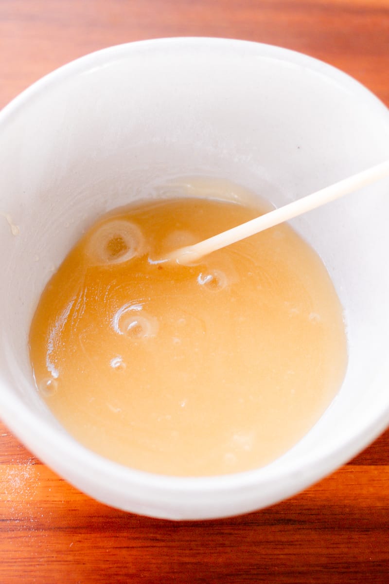 A homemade face mask using baking soda in a small white bowl.