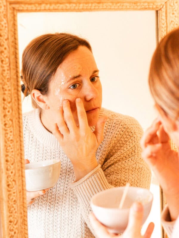 Applying a baking soda face mask to my skin.