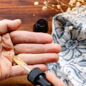 Homemade hair growth oil being dispensed into my hand before working it into the strands.