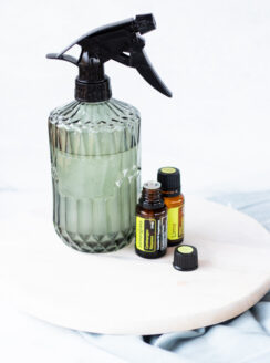 A homemade room spray with fragrance oils next to it.