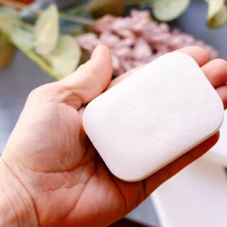 Holding a bar of coconut oil soap to see the beauty of it.