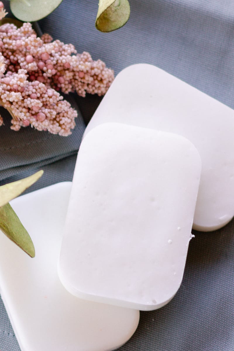 Cold process coconut oil soap bars arranged on a blue tea towel before use.