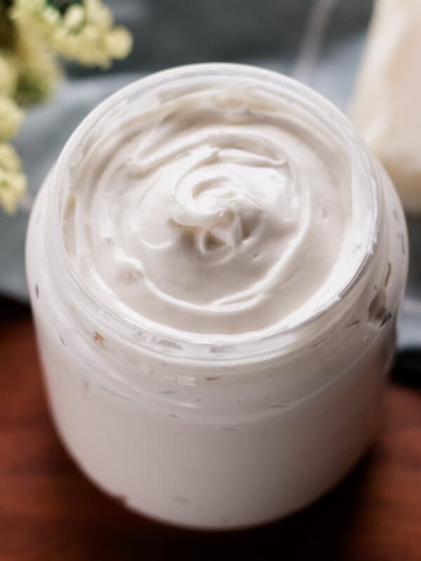 Homemade hair butter recipe in a clear jar on a wooden table.