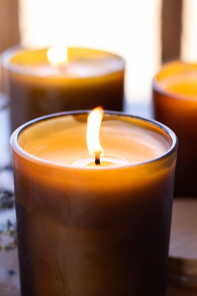 3 coconut wax massage candles burning.