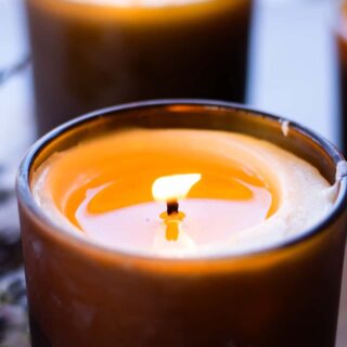 Burning a massage candle to melt the wax and let it pool up before applying to the skin.