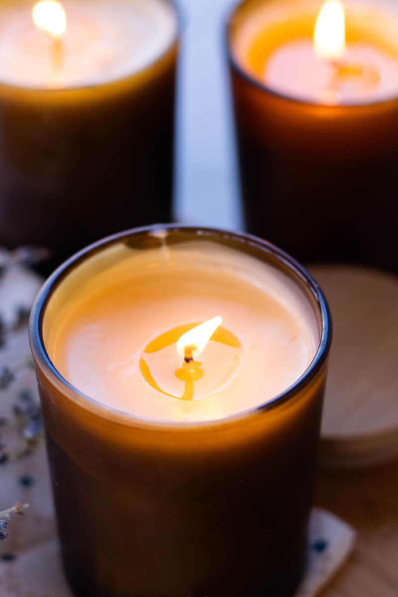 Burning a massage candle to melt the wax before massaging onto the skin.