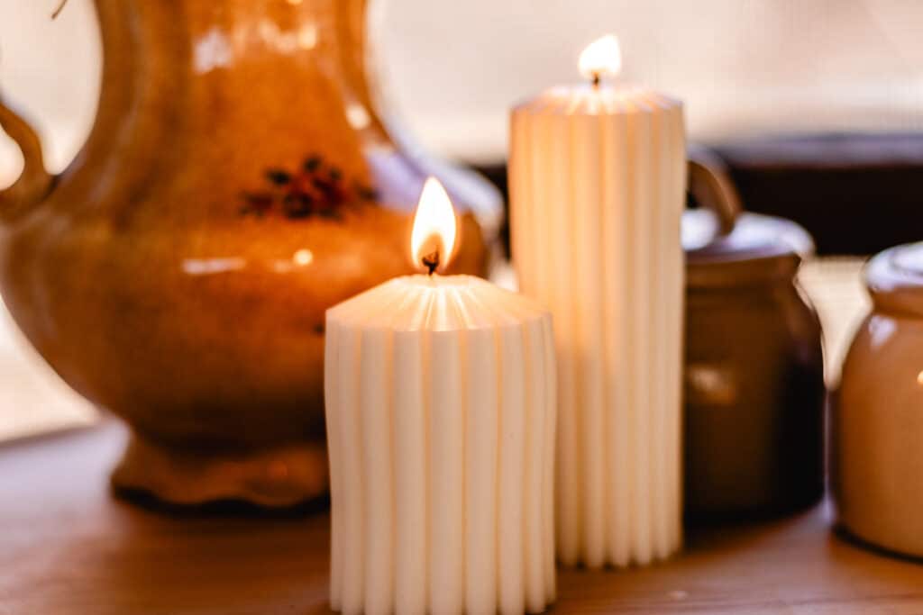 two burning scalloped pillar candles