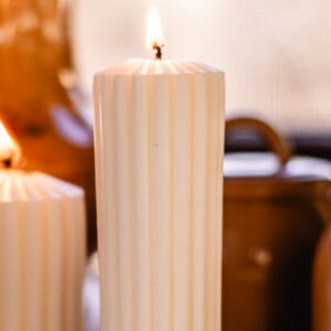 Lighting a pillar candle after the wick has been trimmed.