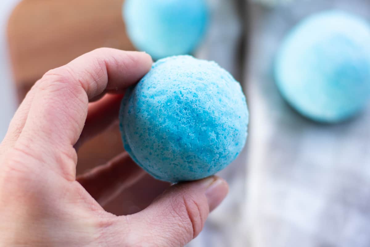 Holding one of the shower bombs after it has been dried and removed from the metal mold.