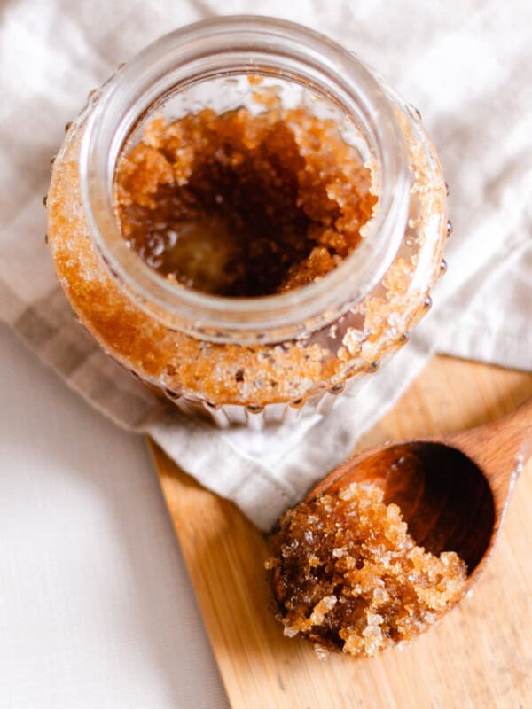 Scalp scrub recipe in a decorative glass jar on a marble vanity.