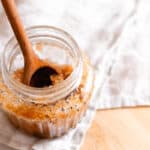 Scalp scrub being stirred with a wooden spoon.