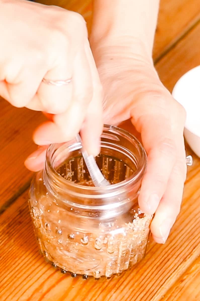 Stirring the scalp scrub ingredients well with a metal spoon.