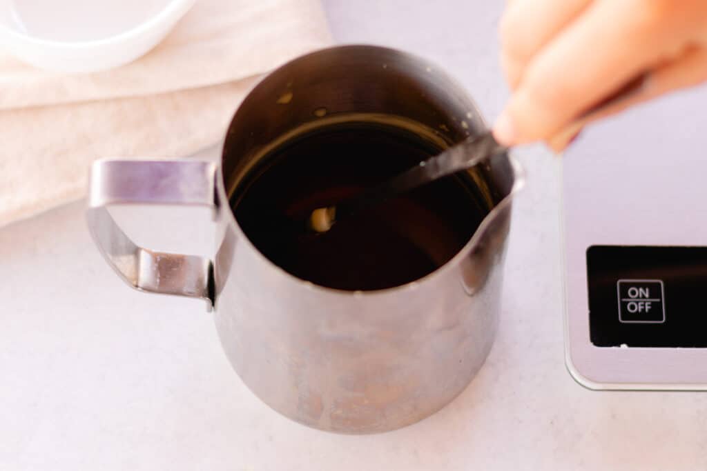 Stirring in the honey vanilla fragrance oil into the melted candle wax.