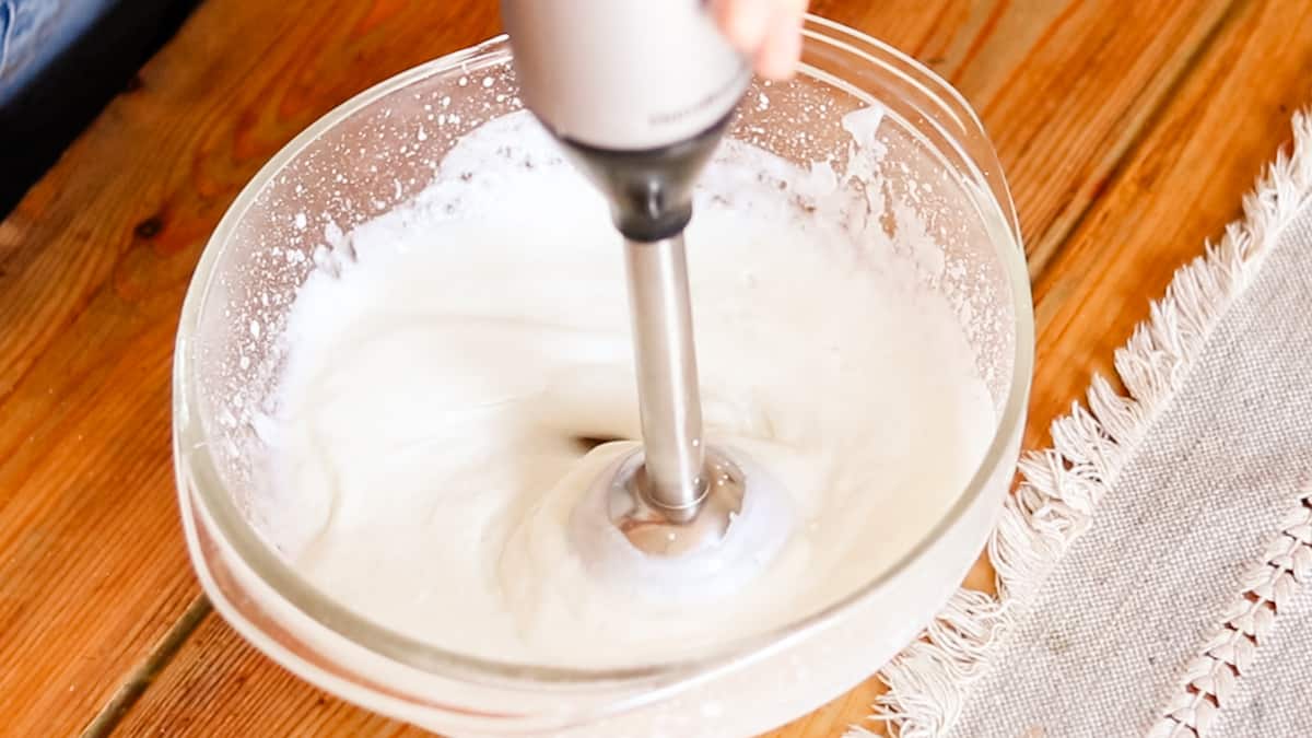 Using the immersion blender a second time to combine all the ingredients for the foot lotion.