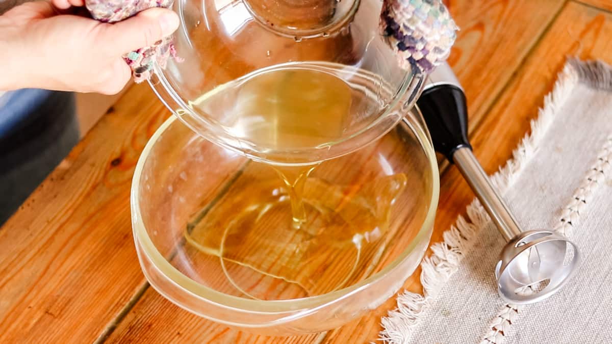 Adding the melted oils to a clear mixing bowl.