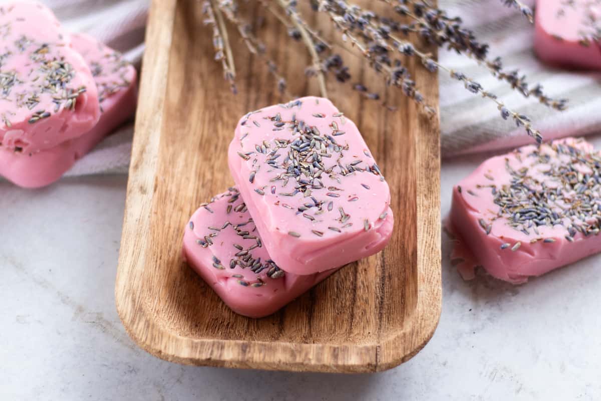Several bars of pink lavender soap with lavender buds pressed into the bars.