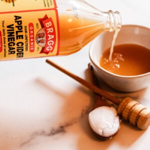 Adding apple cider vinegar to the curly hair mask mixture.