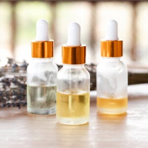 Anti wrinkle serums on a wooden table with a white dropper top and clear bottles they are stored in.