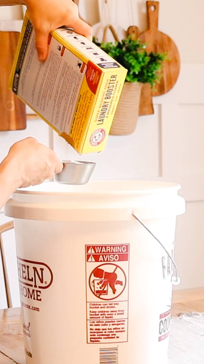 Measuring out washing soda and pouring into the large bucket. 