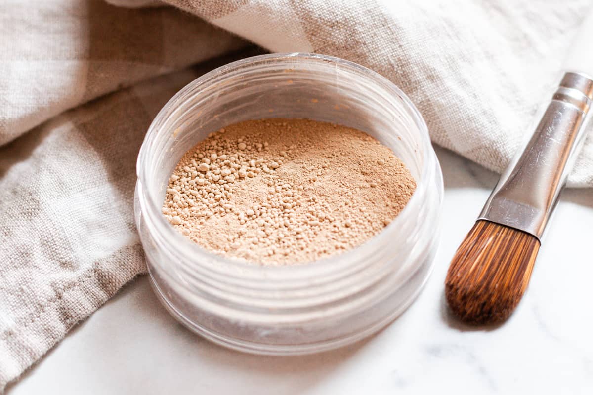 Jar of mineral makeup and a makeup brush.