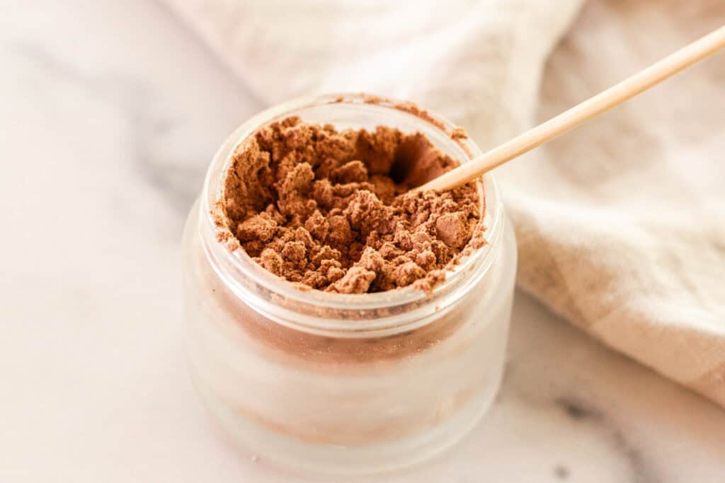 Stirring the mixture to make diy mineral makeup.