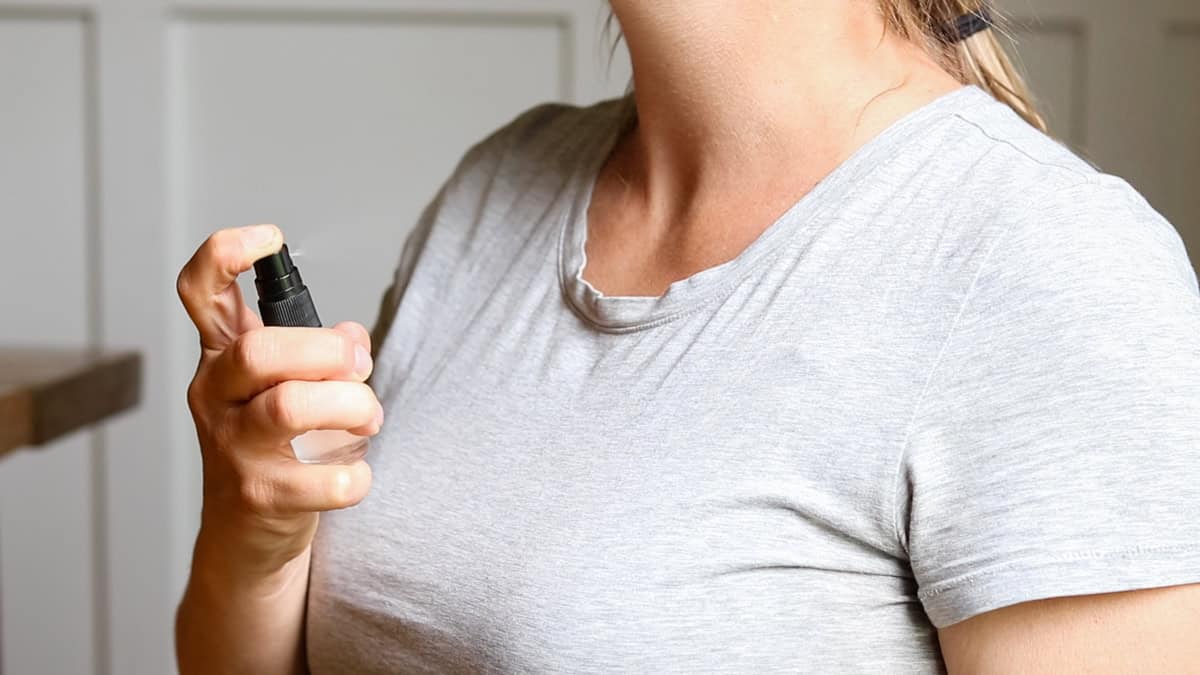 Applying homemade spray perfume by misting it onto the neck. 