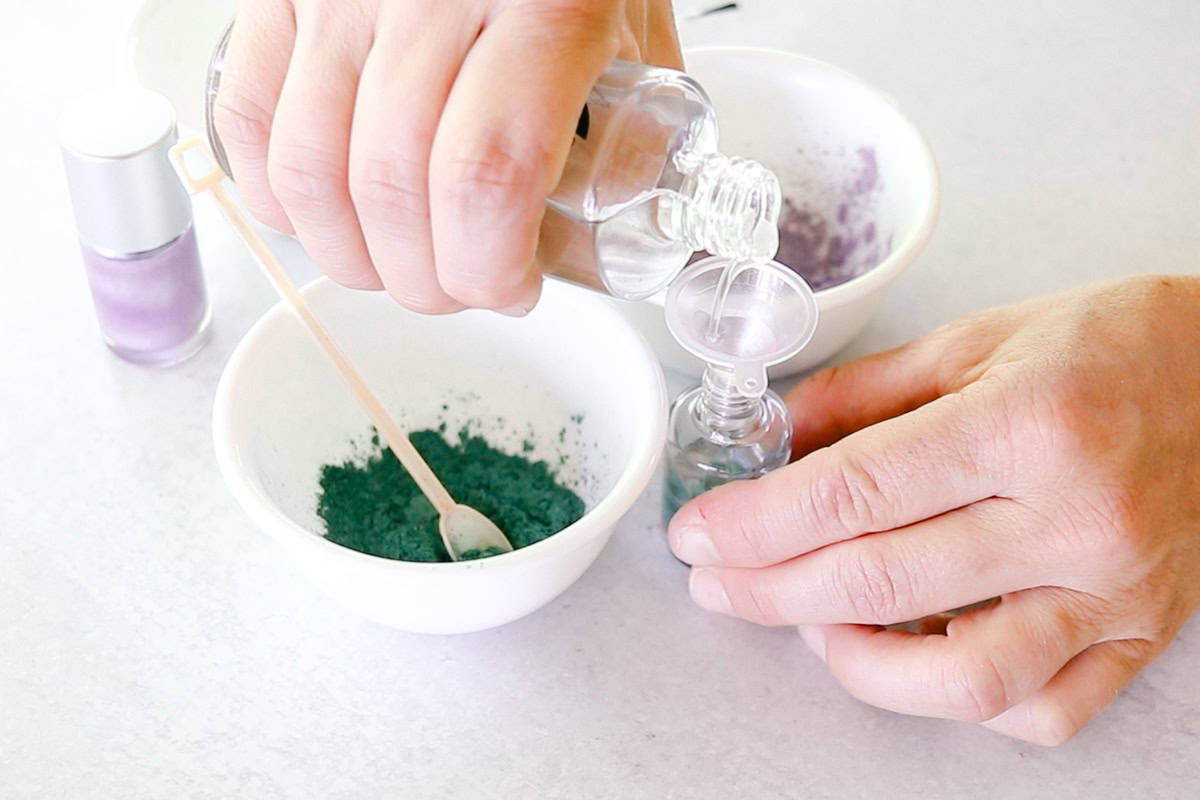 Pouring the clear suspension base into the nail polish bottle funnel. 