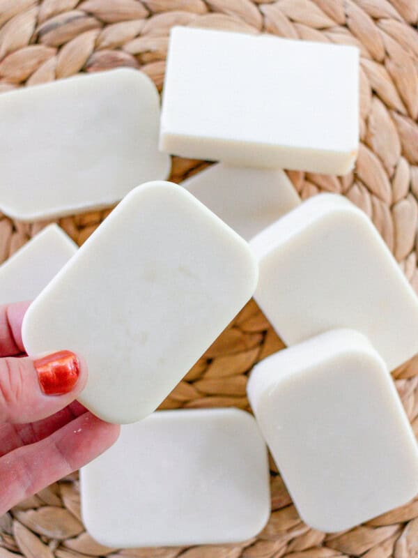 Several facial soap bars curing on a wicker drying rack.
