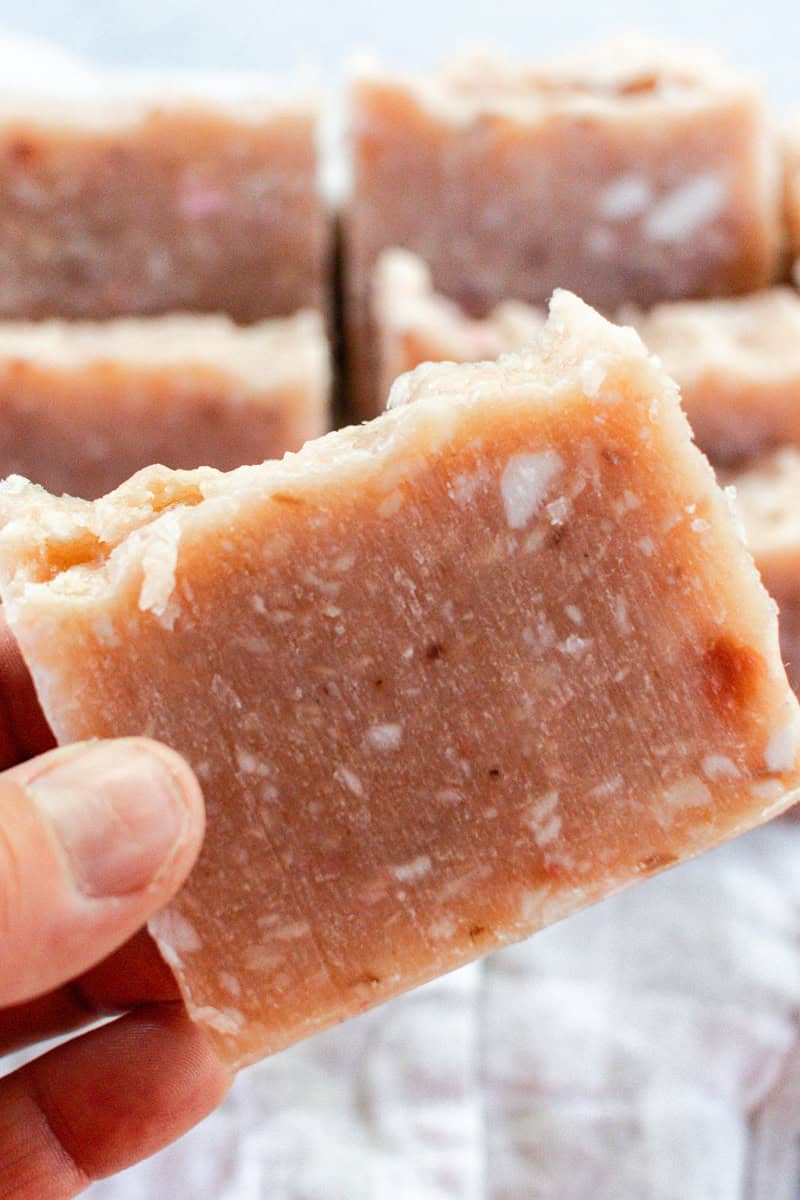 Holding a bar of pink rebatch soap. 