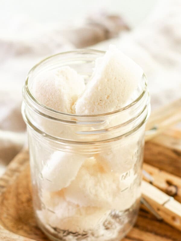 Laundry soap pods in a small, clear container.