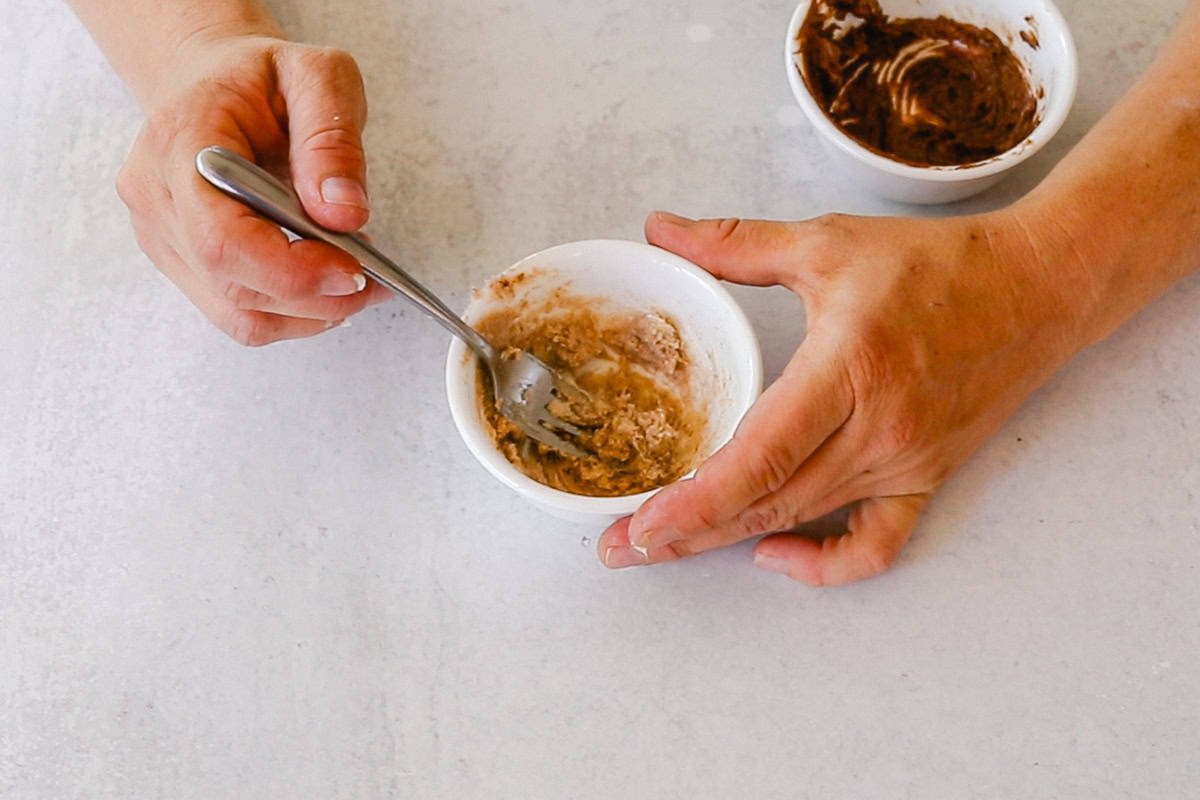 Stirring a bowl of cinnamon and shea butter to create homemade lip plumper. 