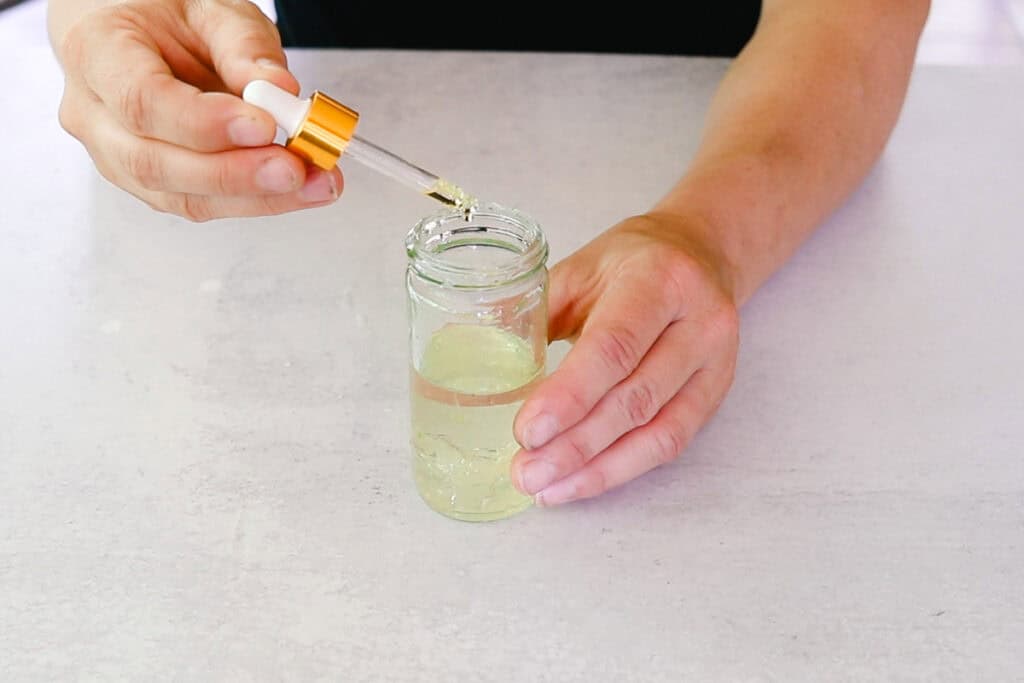 Using a dropper to add the preservative to the beaker.