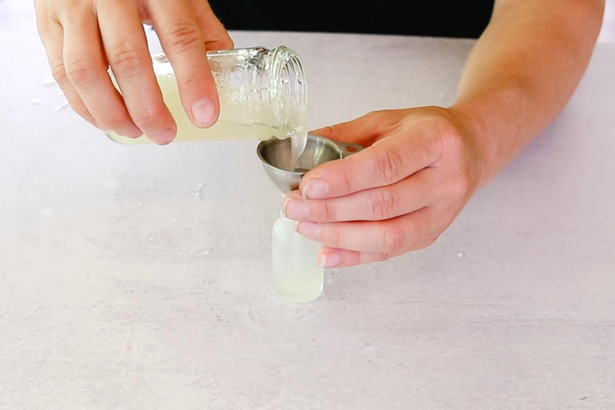 Pouring the eye serum into a dropper bottle.