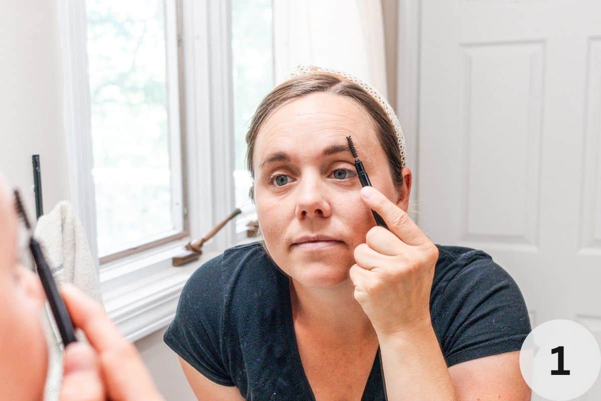 Brushing eyebrows with a small brow brush.