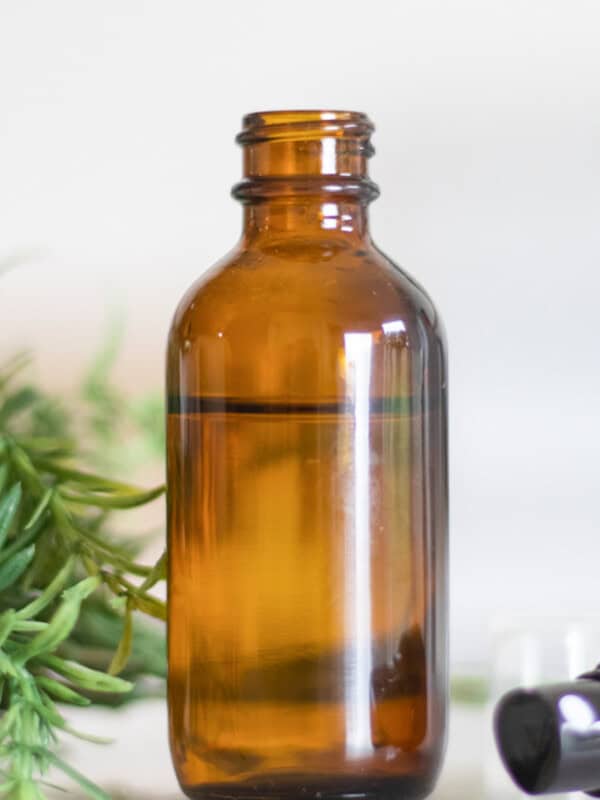 An amber glass spray bottle with homemade ant repellent in it.