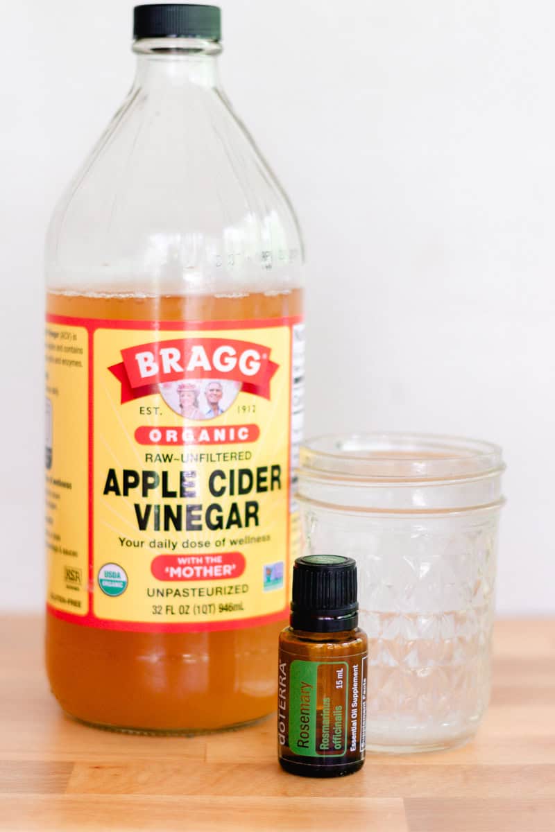 Ingredients for apple cider vinegar clarifying shampoo: apple cider vinegar, rosemary essential oil, and water.