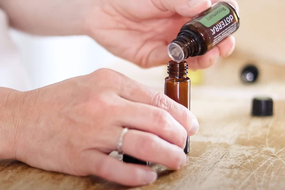 Adding rosemary oil to the empty roller bottle. 