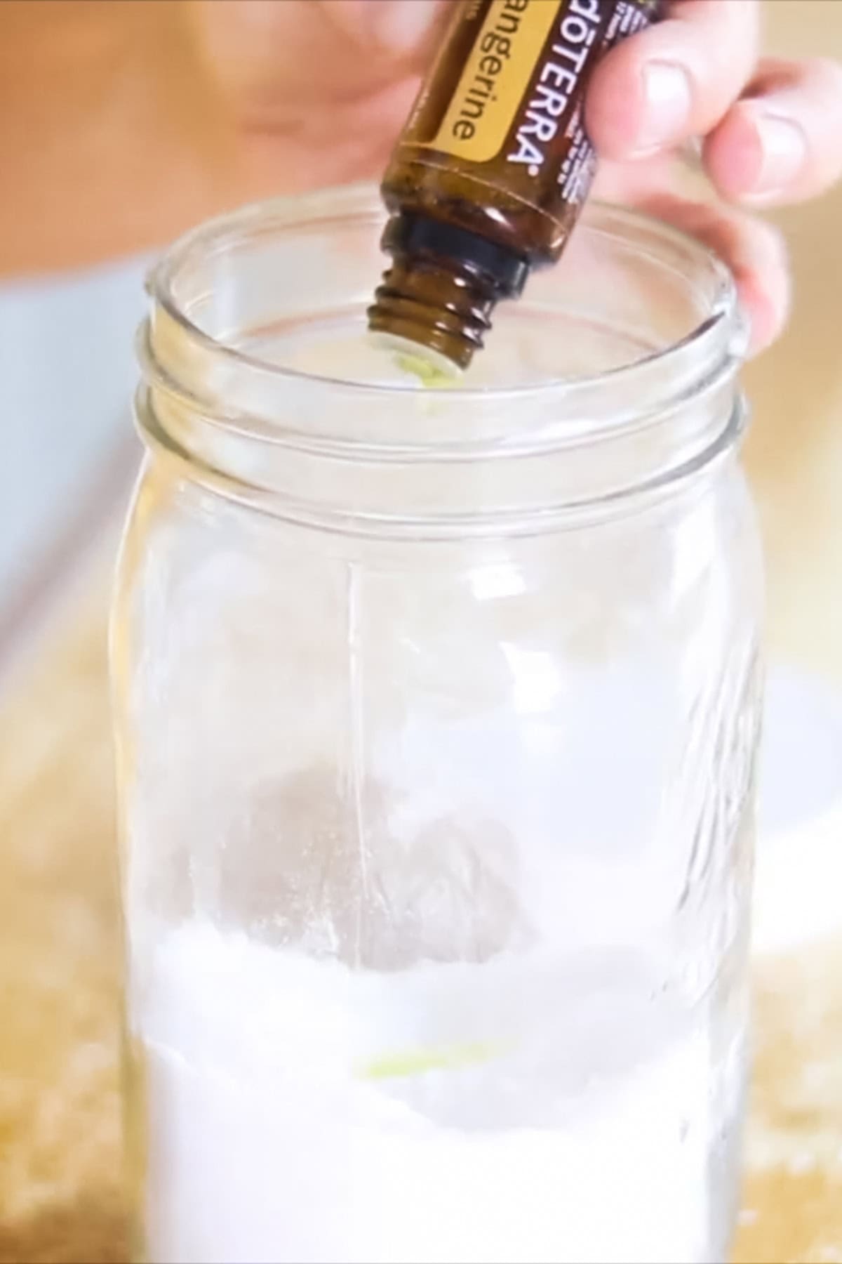 Adding essential oils to a jar of laundry scent boosters.