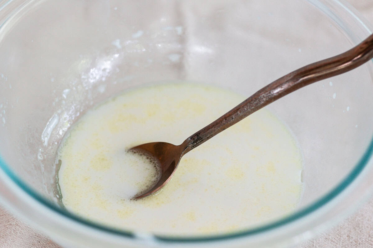 Mixing ingredients in a glass bowl to make leave-in conditioner.