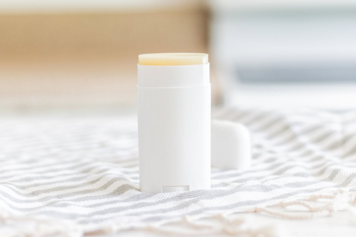 Deodorant stick on a blue and white striped tea towel with the top slightly twisted up. 