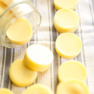 Homemade lotion bars on white and gray towel in a mason jar.