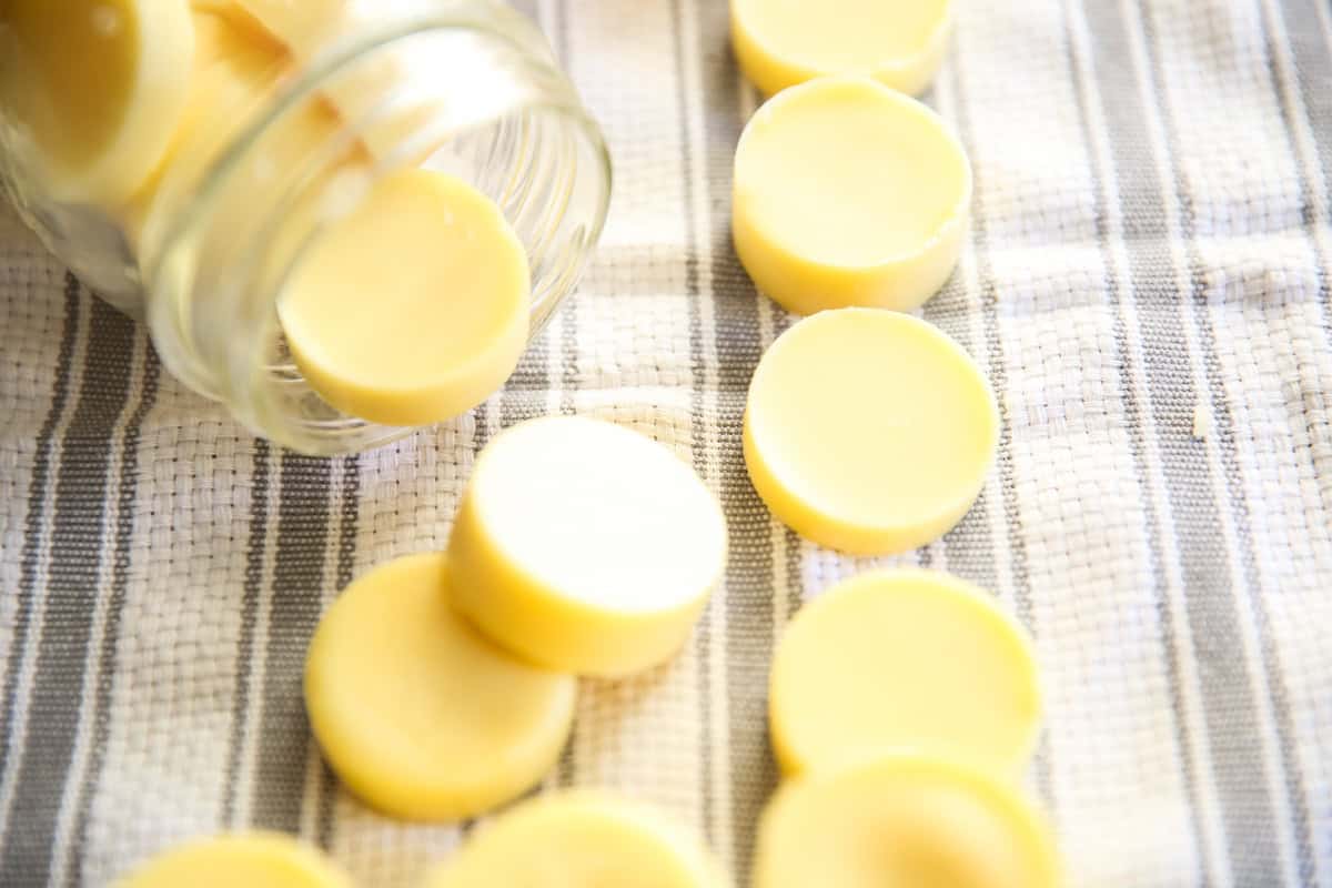 Homemade lotion bars on white and gray towel in a mason jar.