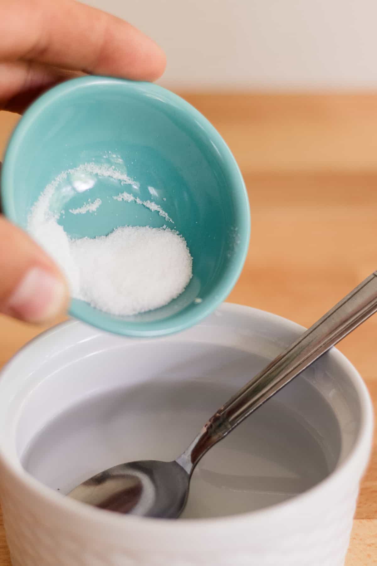 Pouring the sea salt into a bowl with water to make into sea salt spray. 